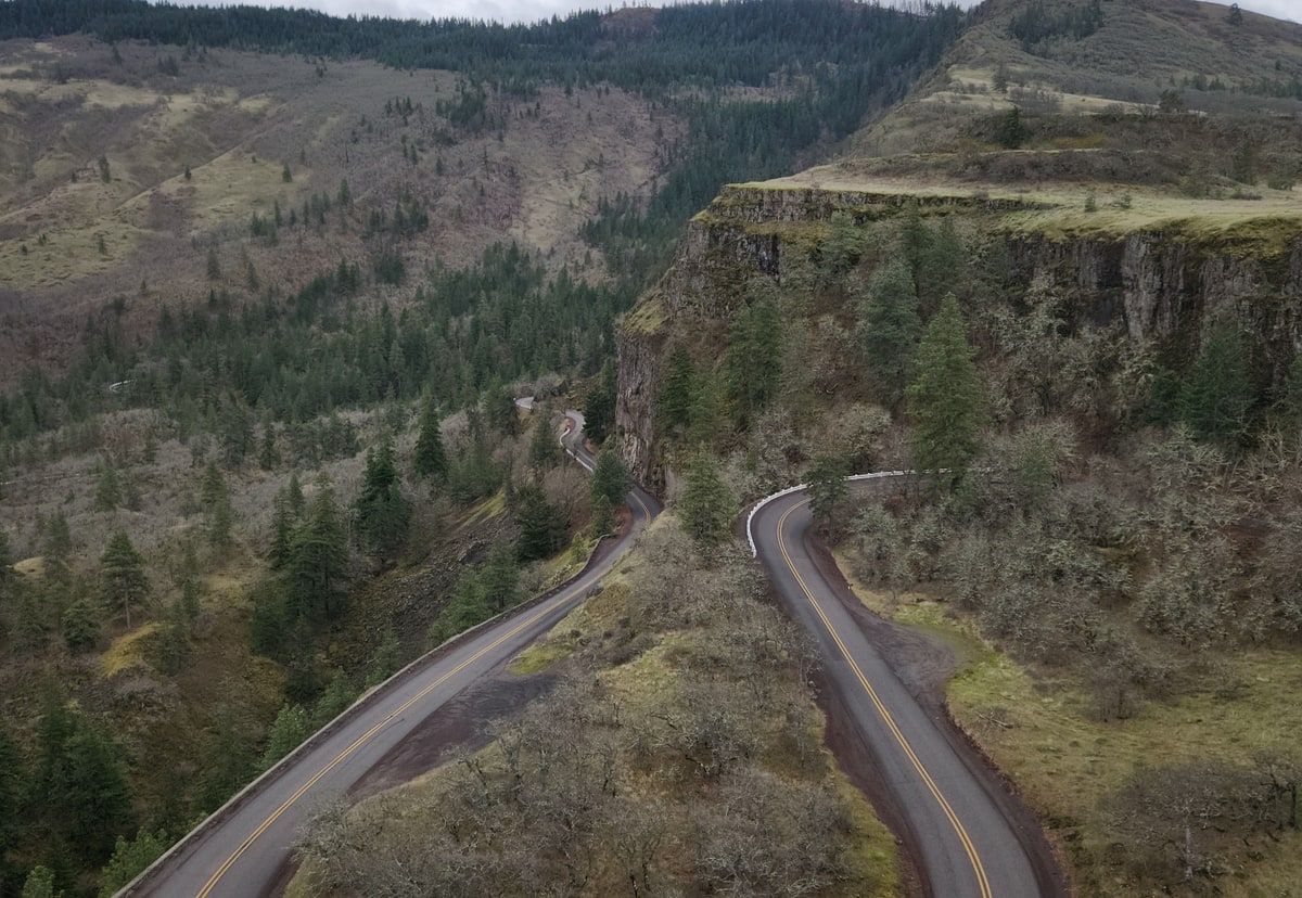 Natural-colour aerial view of a winding mountain road, representing a software plan adapting as more of the route becomes visible