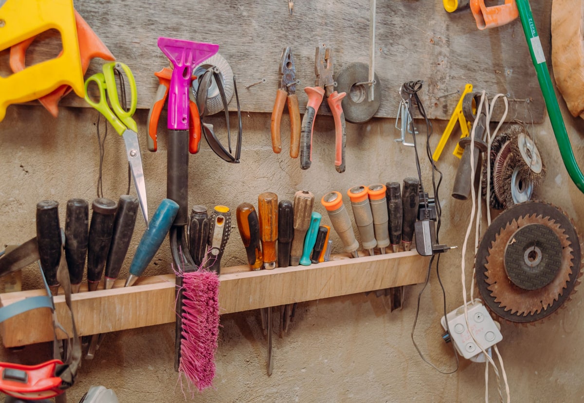 A colourful collection of hand tools organised on a workshop wall
