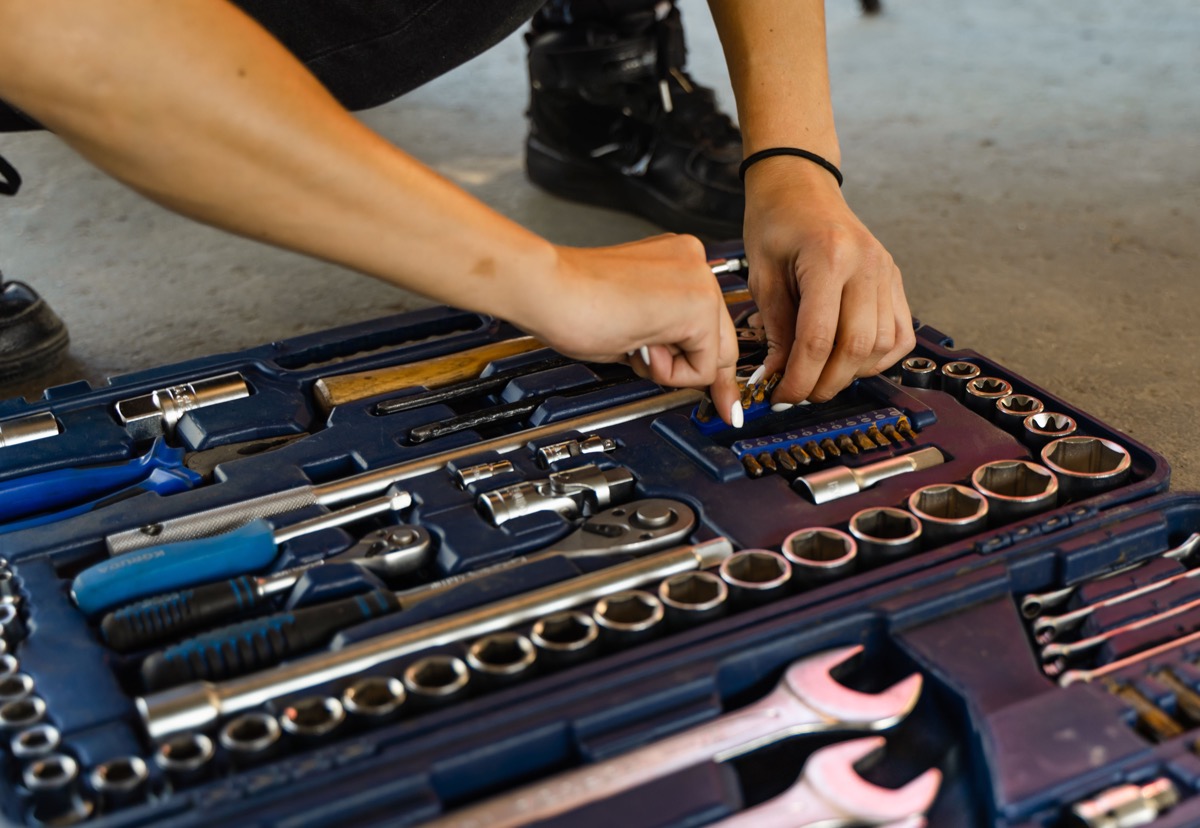 Hands selecting a tool from an organised toolbox, representing the choice between focused and extensive cloud platforms