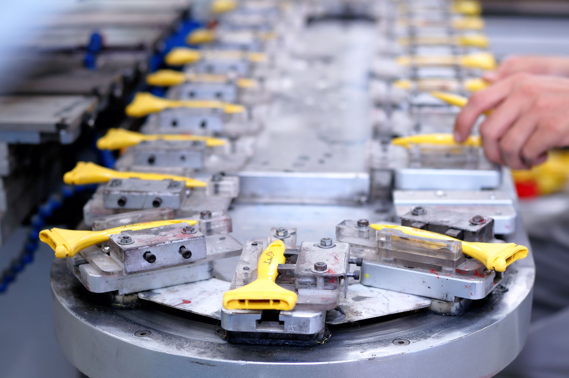 Yellow plastic components moving through a factory production line, representing small software changes passing through repeatable CI/CD checks