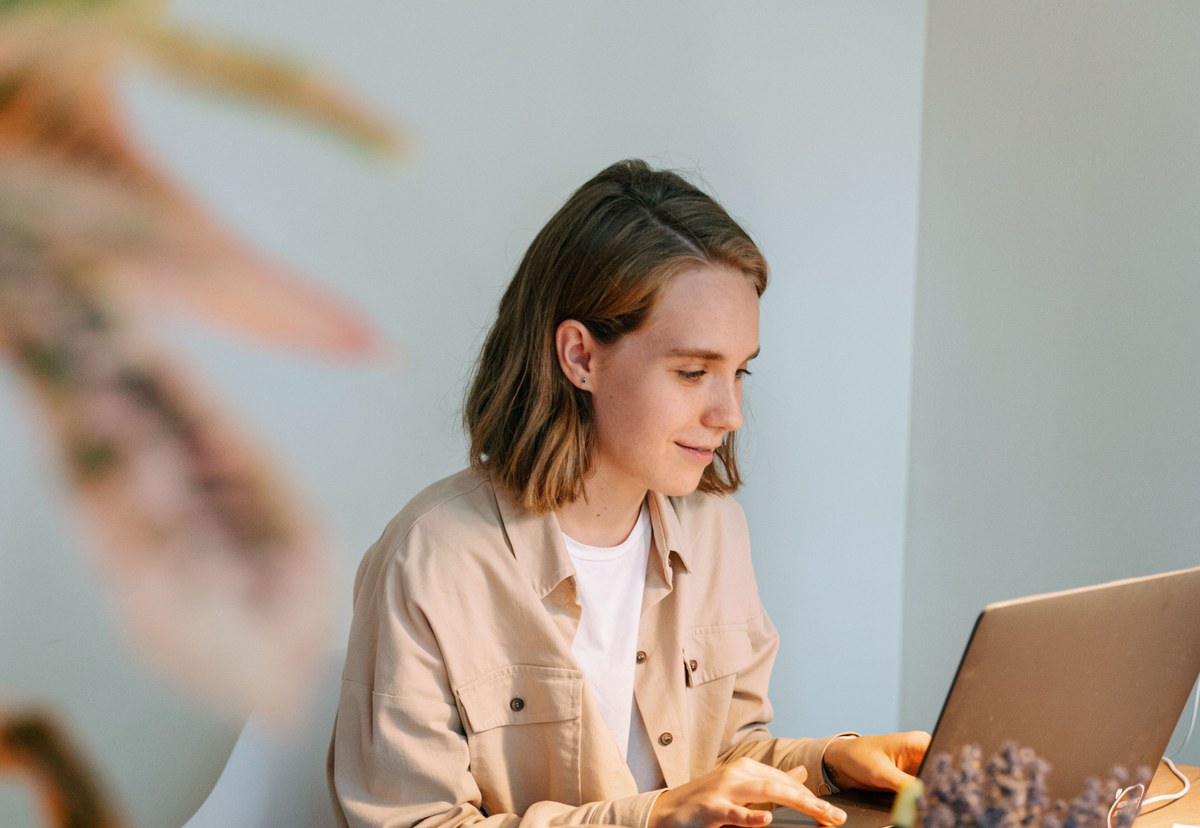 A designer working on a laptop in a bright creative workspace while developing a digital prototype