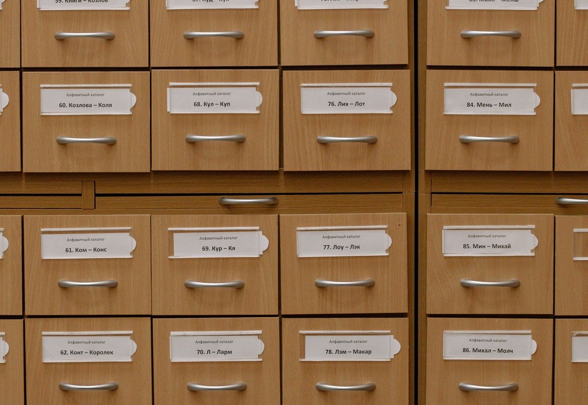 A wall of labelled wooden catalogue drawers representing Laravel settings organised into one clear data structure