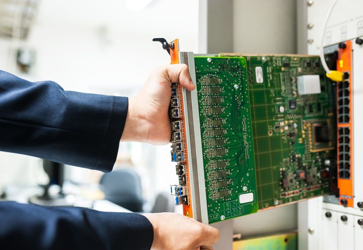 A technician installing a server component into infrastructure hardware, representing the machine layer beneath containerised applications