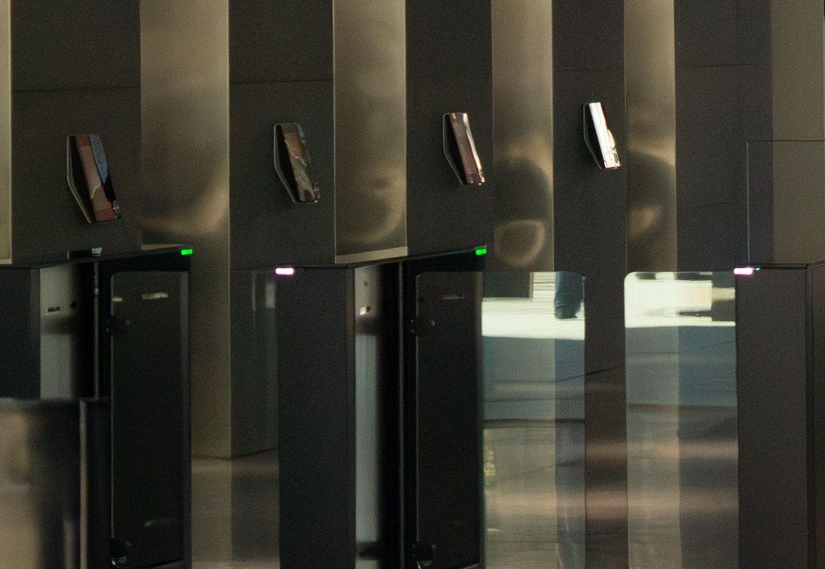 A row of office security turnstiles showing green and red access lights