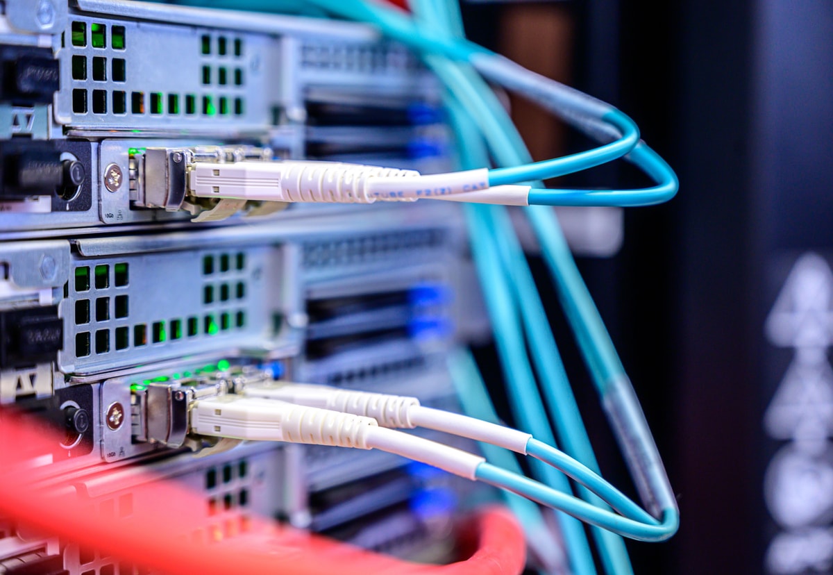 Network cables connected to server ports, representing software systems exchanging information