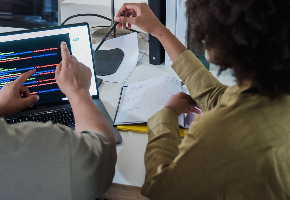 Developers reviewing source code together on a laptop in an office