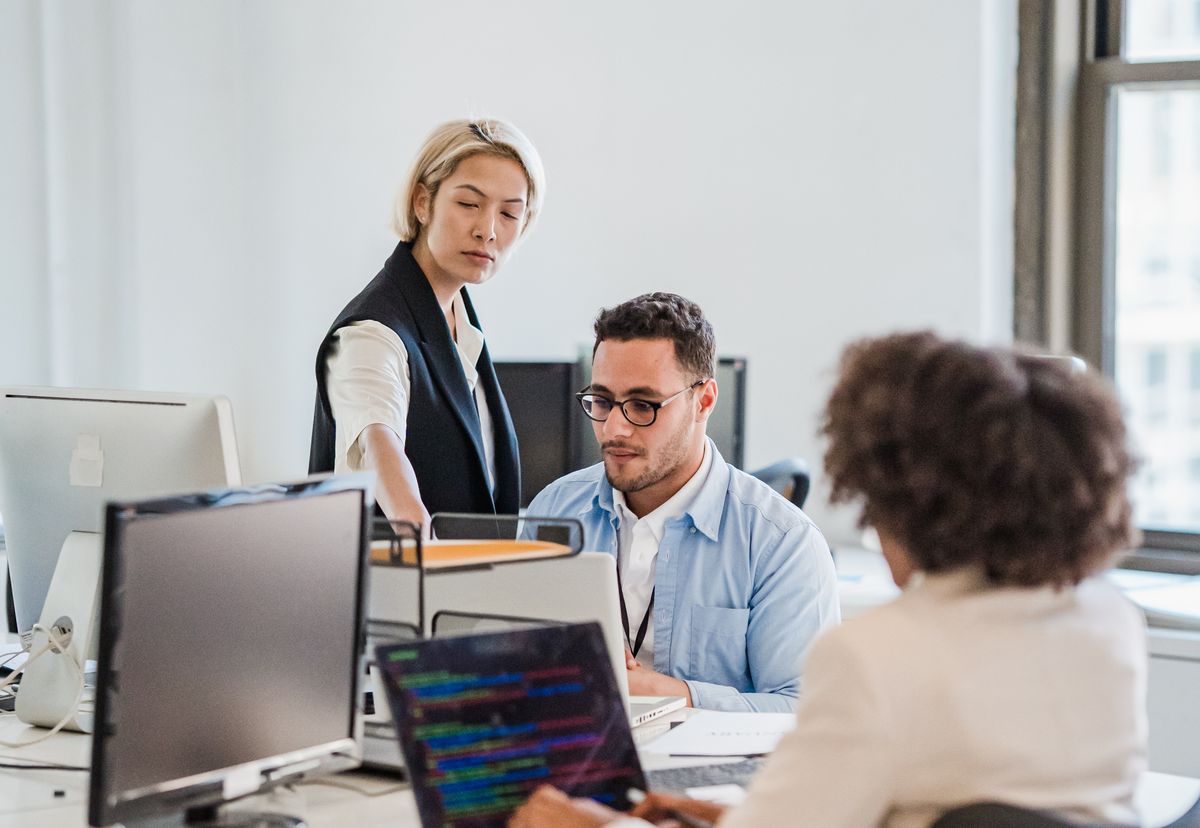 A business team working together with computers in a shared office, representing access to one managed online software service