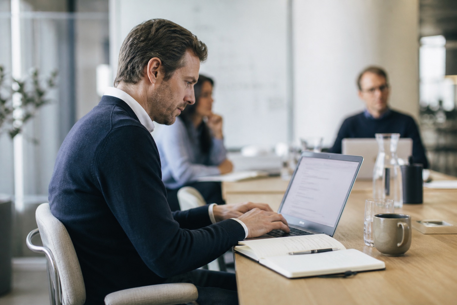 A project lead turning meeting notes into actions on a laptop