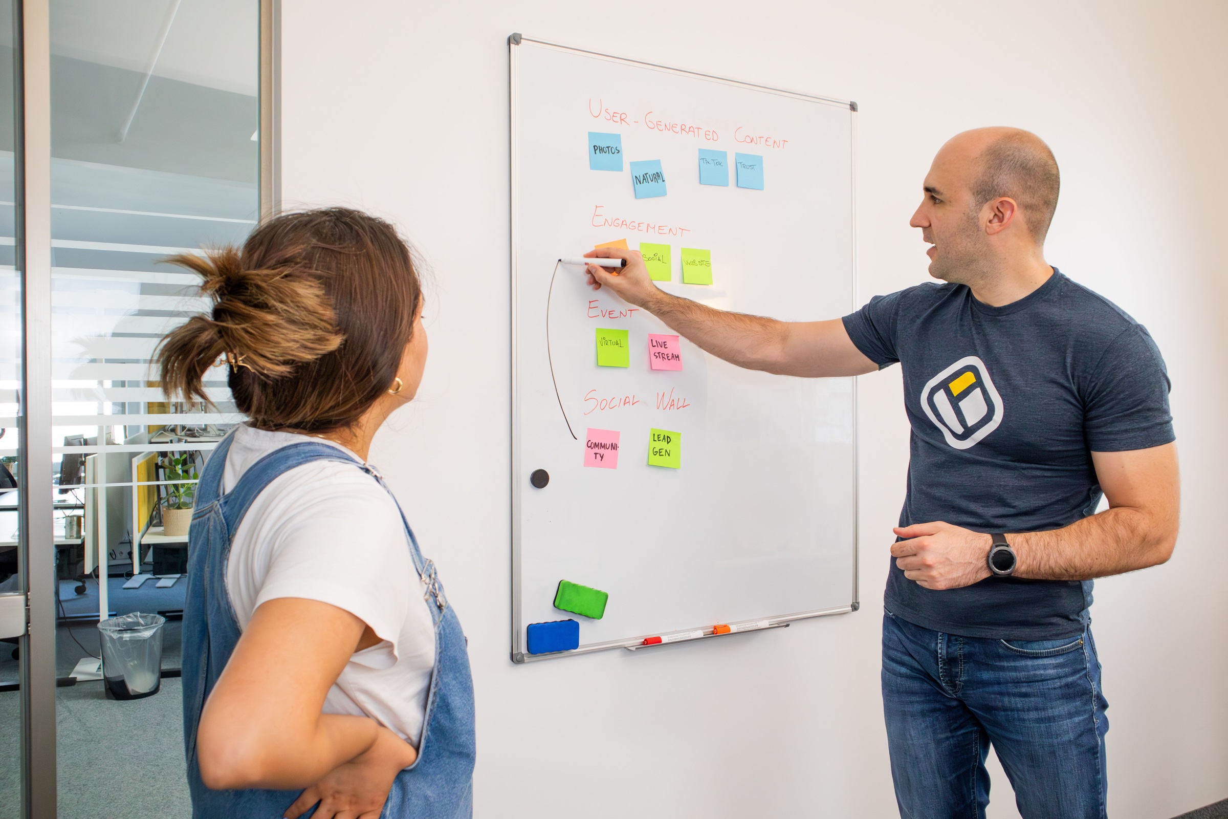 Two people discussing ideas and user journeys on a whiteboard